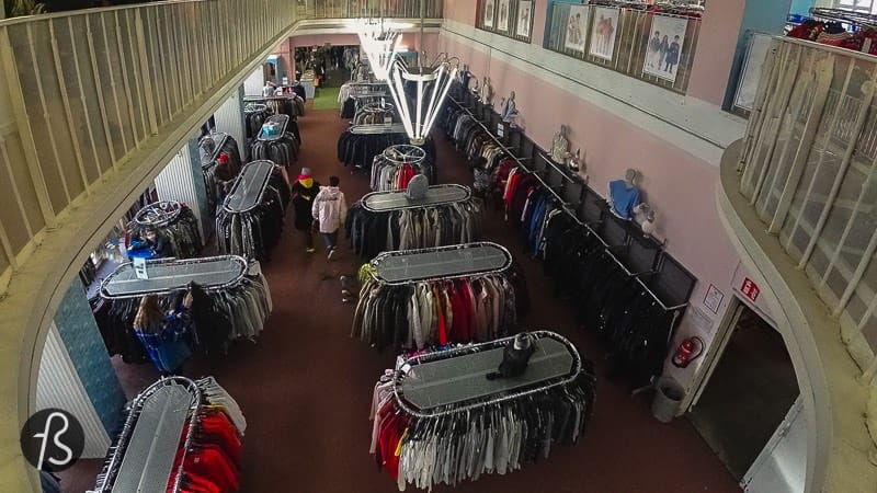 I believe it happens in the second episode when Beth’s adoptive mother takes her shopping. There is an outside scene where they cross a road that is clearly not in Berlin. But once they are in the shop, they are back in Germany. The exterior shots were done in Toronto, but inside, they are in Berlin-Friedrichshain.