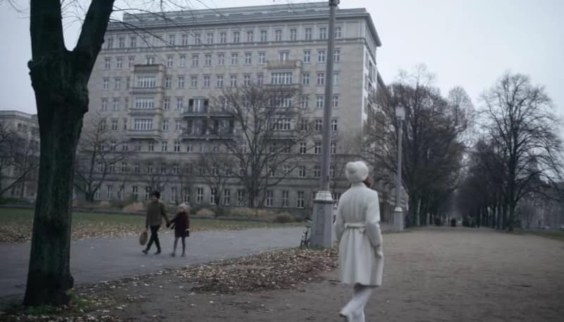 Everything happens around the Rosengarten on Karl-Marx-Allee. Beth walks away from a car and goes through the garden. She turns between some trees and sees the chess players. As you can see in the pictures we took, it looks almost the same as in the series.
